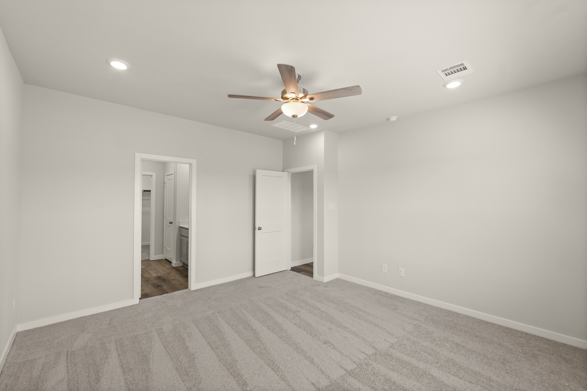 A room with a ceiling fan and a door.