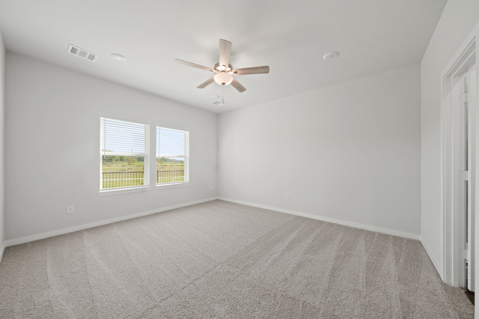 A room with a ceiling fan and a window.