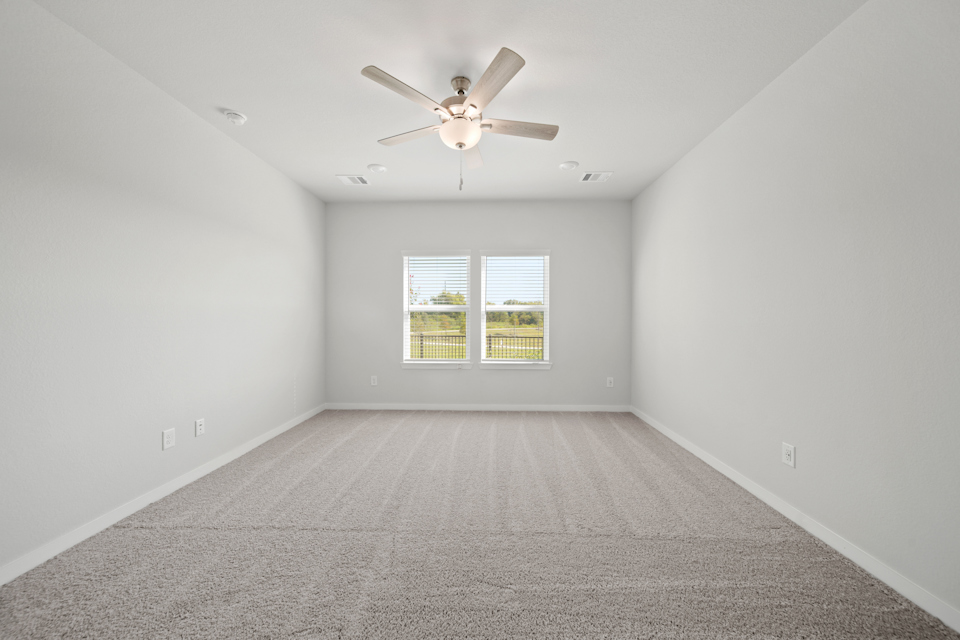 A room with a ceiling fan and a window.
