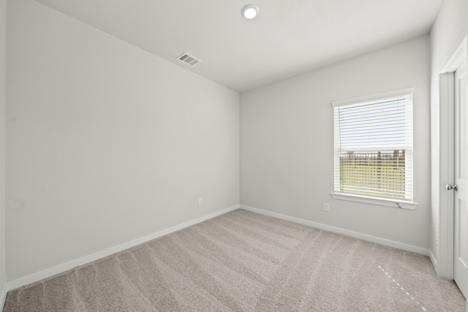 A room with a window and a carpet.