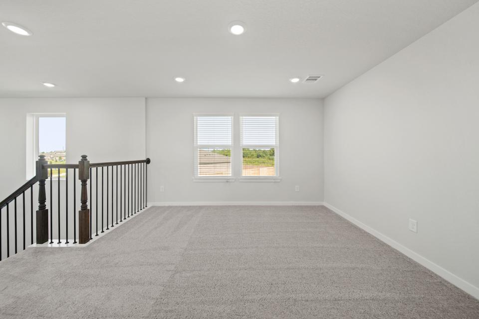 A room with a railing and windows.