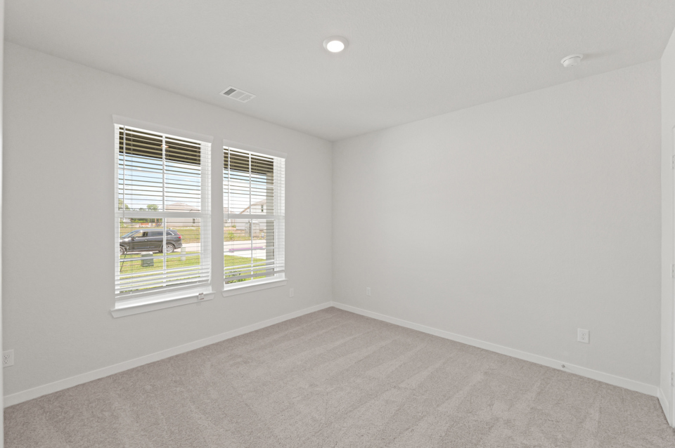 A room with a window and a white wall.