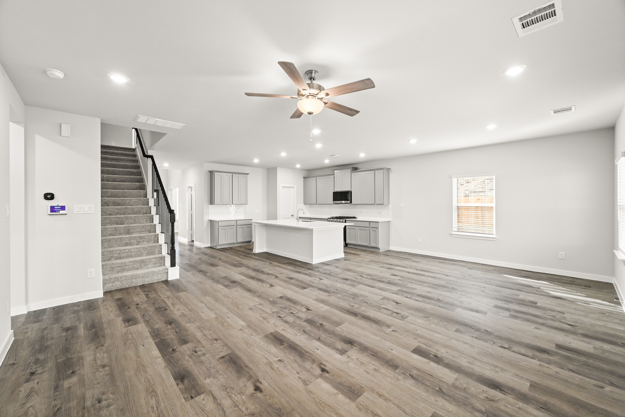 A large empty room with a wood floor and a wood floor.