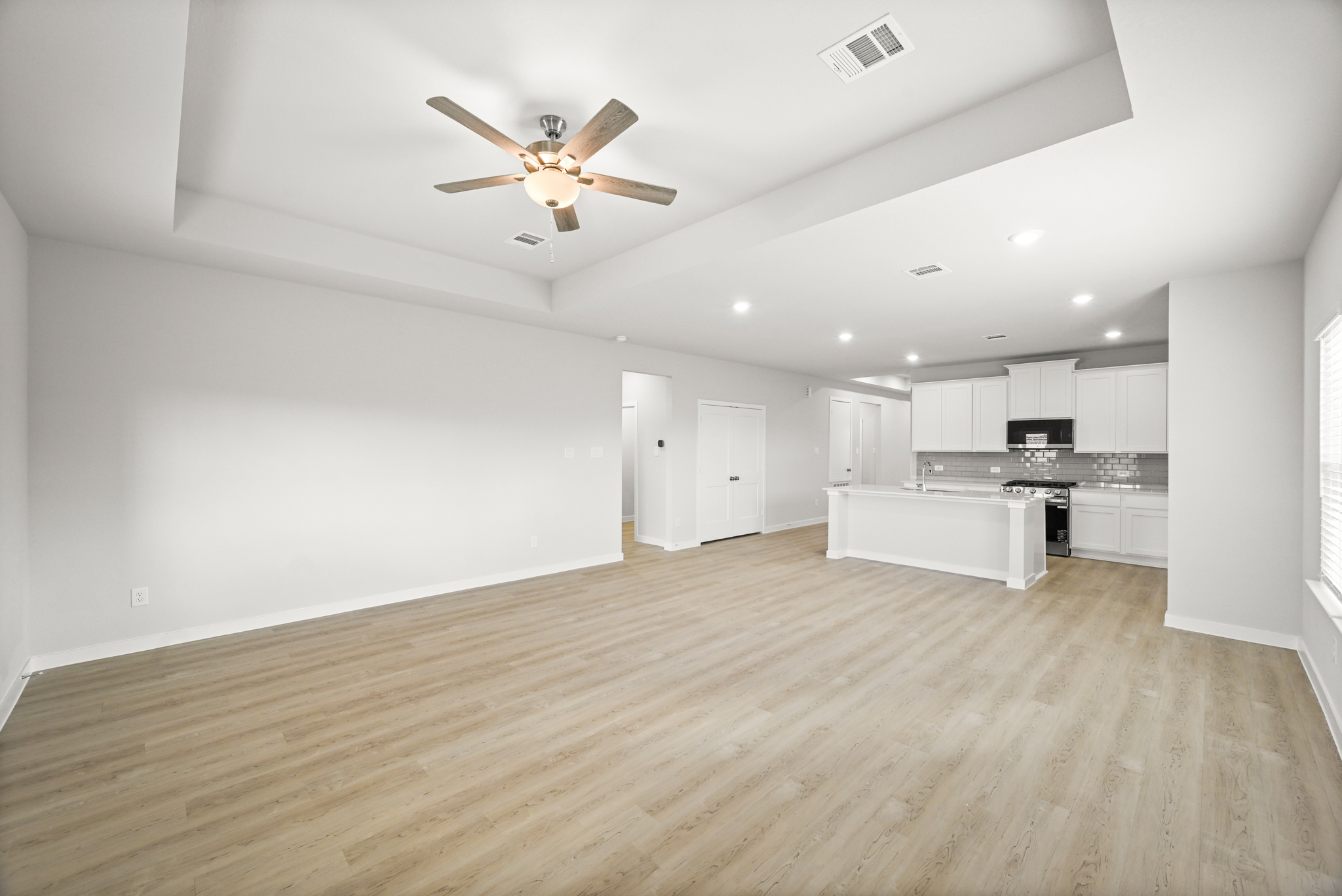 A large kitchen with a ceiling fan.