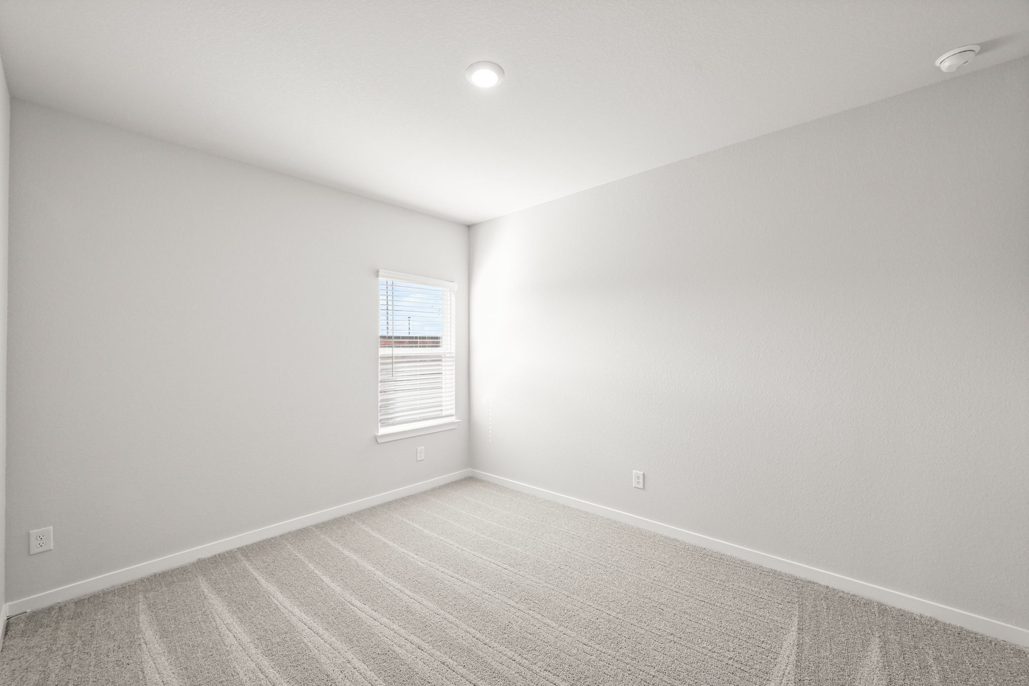 A room with a white wall and a window.