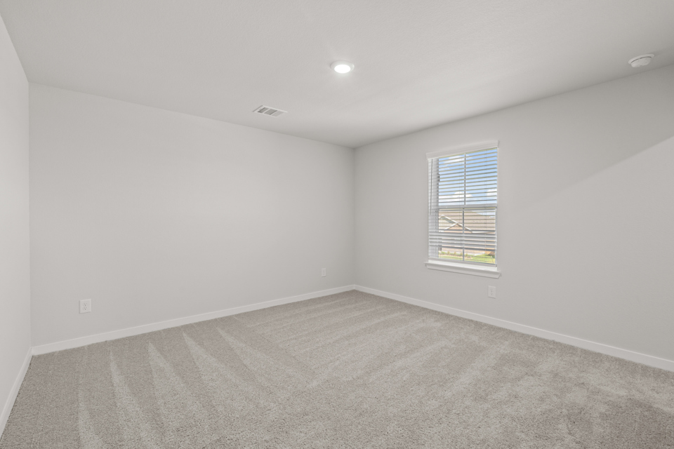 A room with a window and carpet.