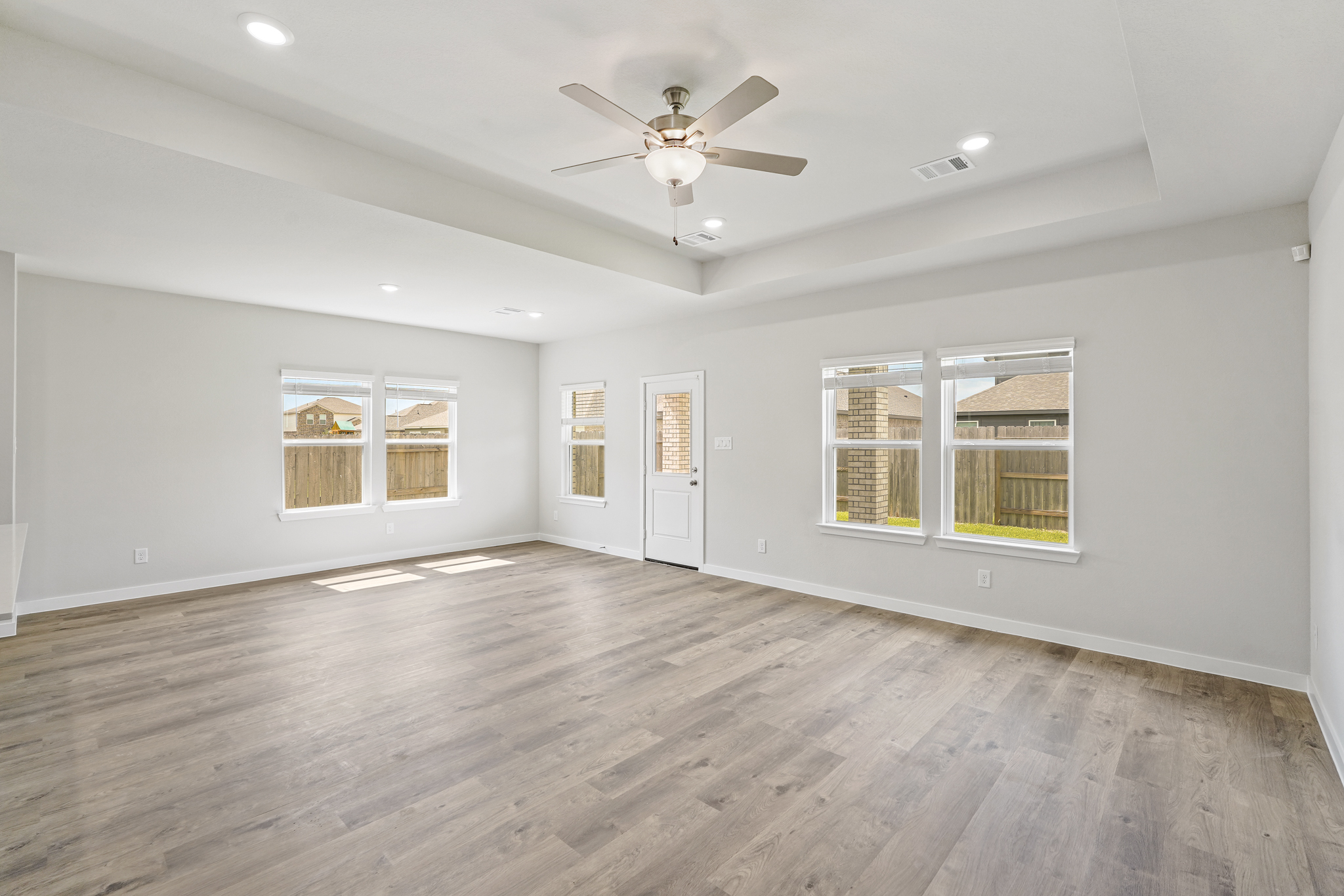 A room with a wood floor and a ceiling fan.