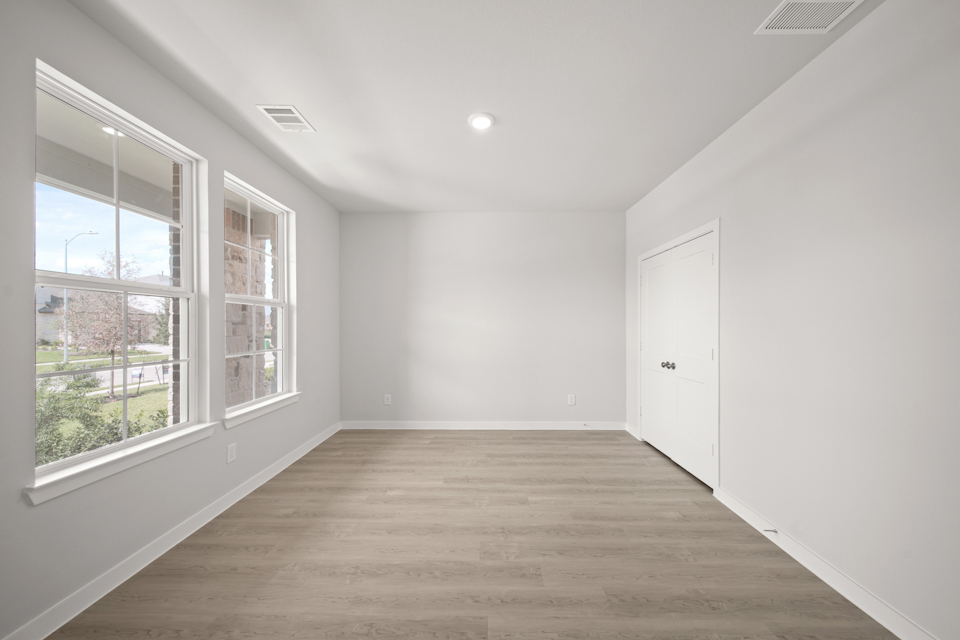 A room with windows and a wood floor.