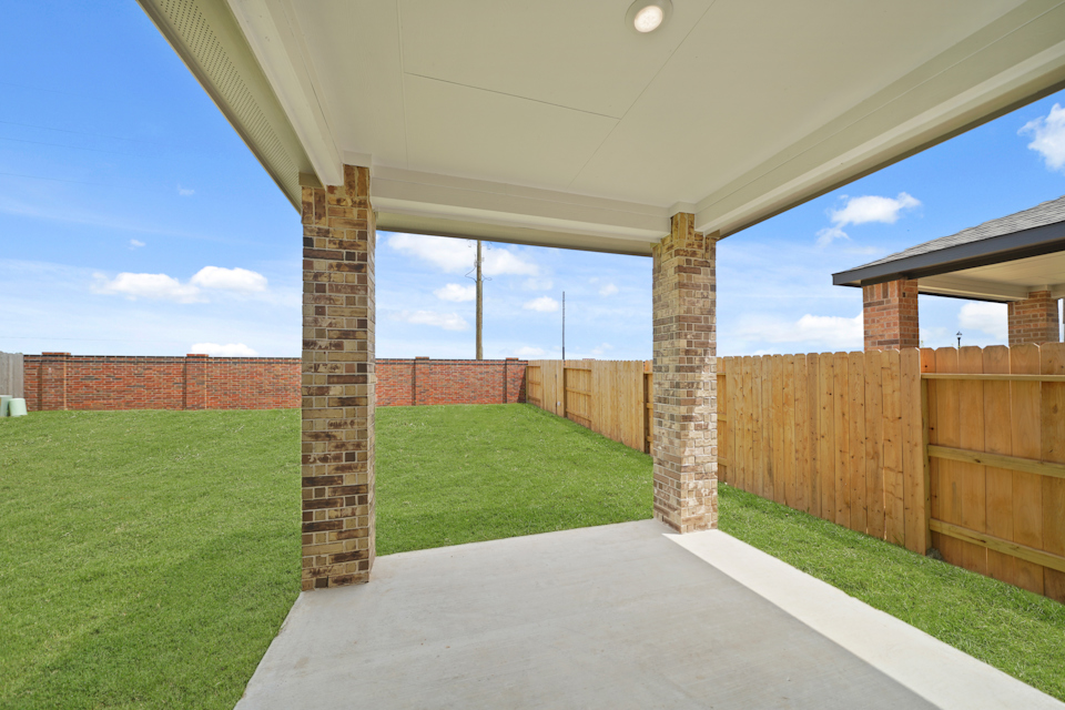 A walkway with a fence and grass.