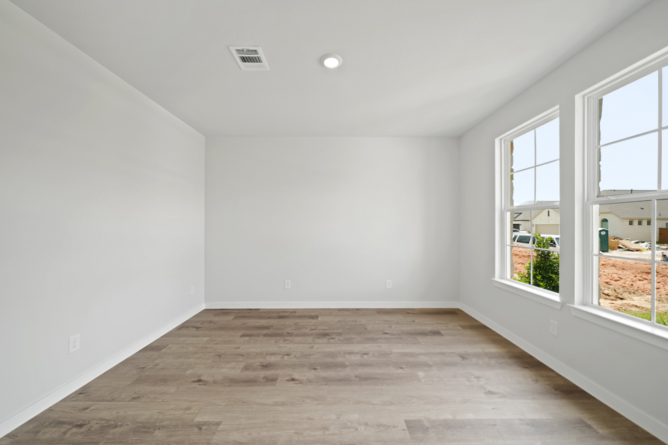 A room with windows and a wood floor.
