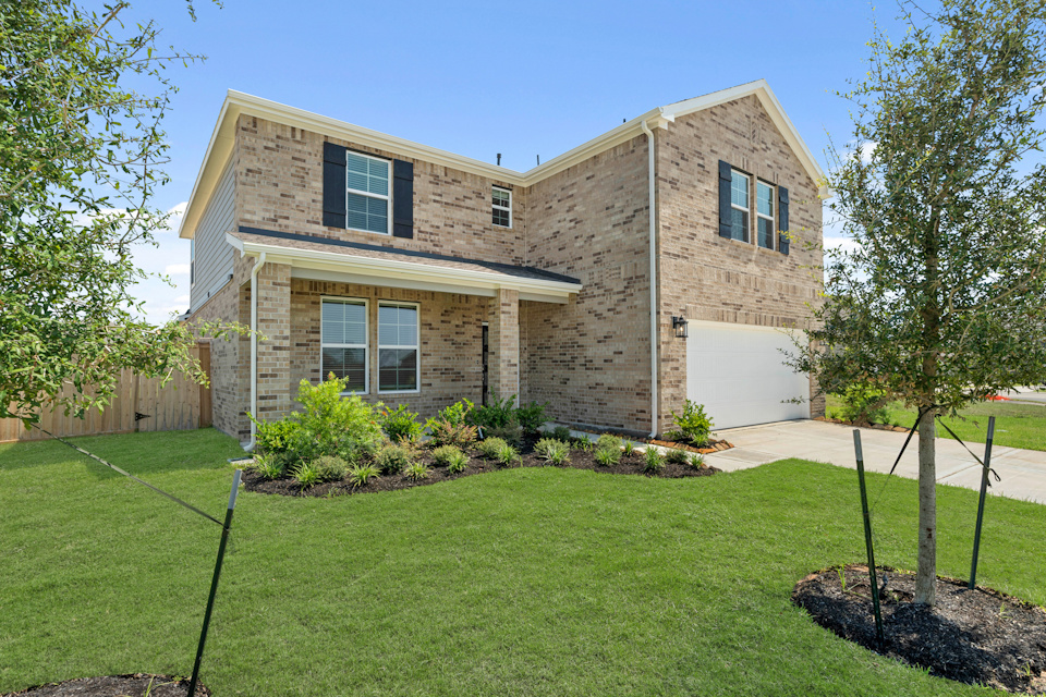 A brick house with a lawn.