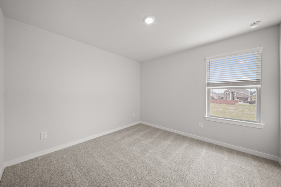 A room with a window and a carpet.