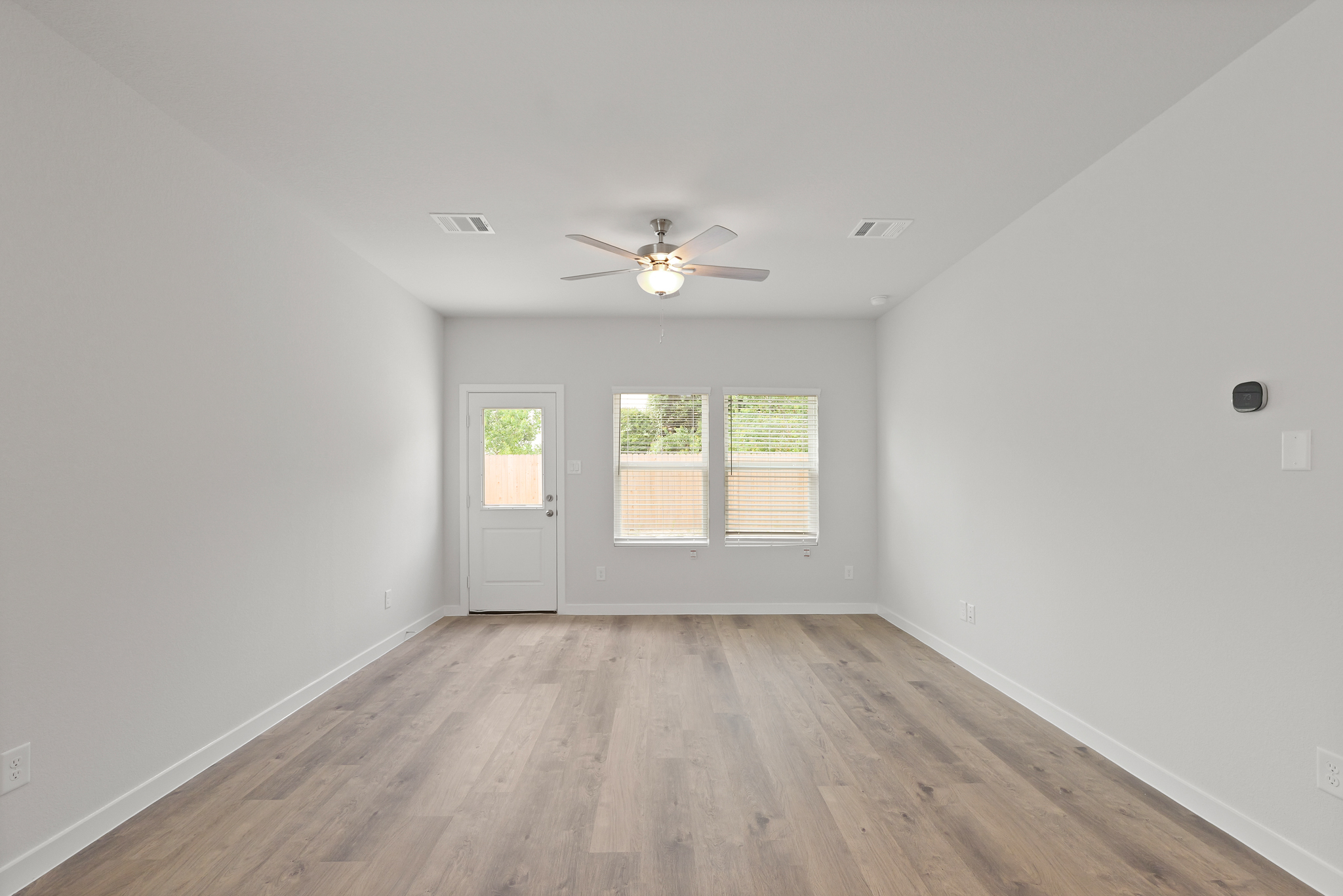 A room with a wood floor and a ceiling fan.