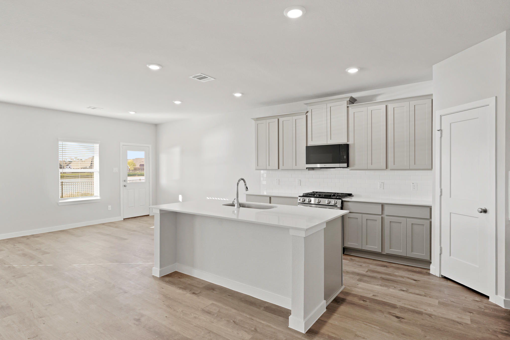 A kitchen with white cabinets.