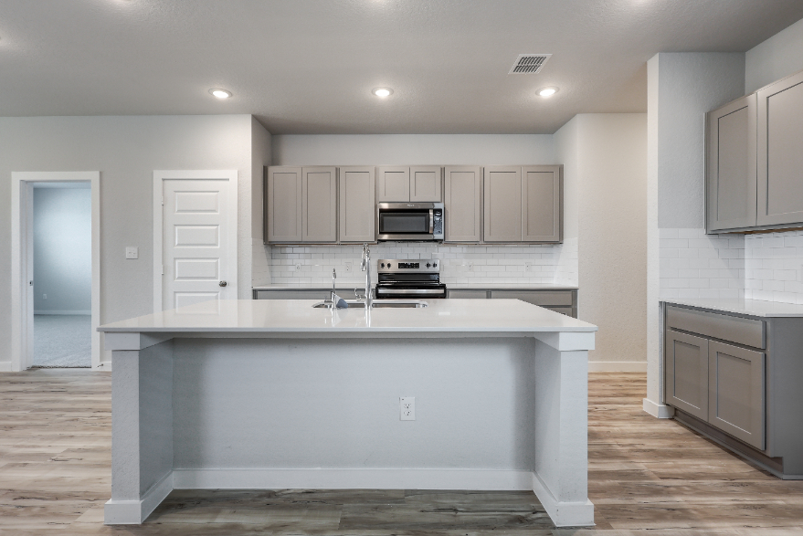 A kitchen with white cabinets.