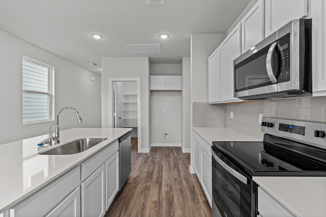 A kitchen with white cabinets.