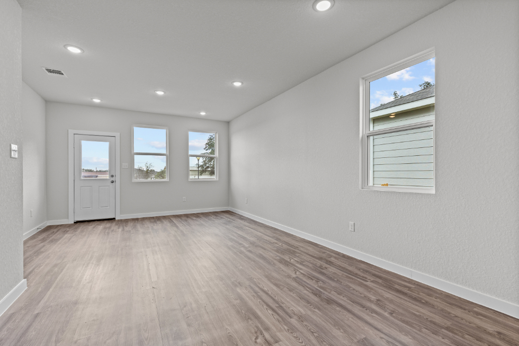 A room with a wood floor and windows.