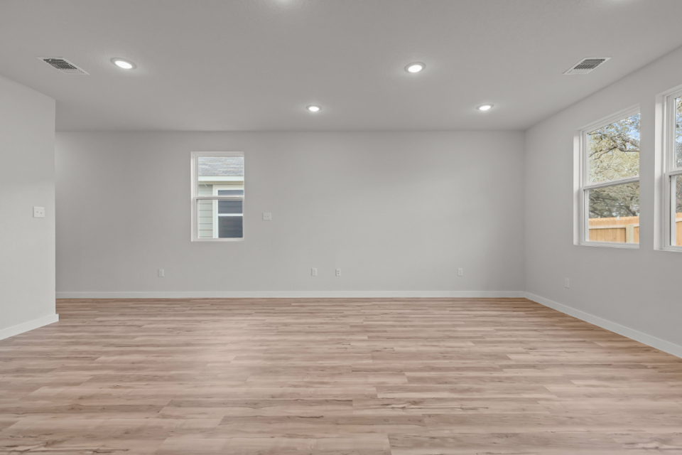 A room with a wood floor and windows.