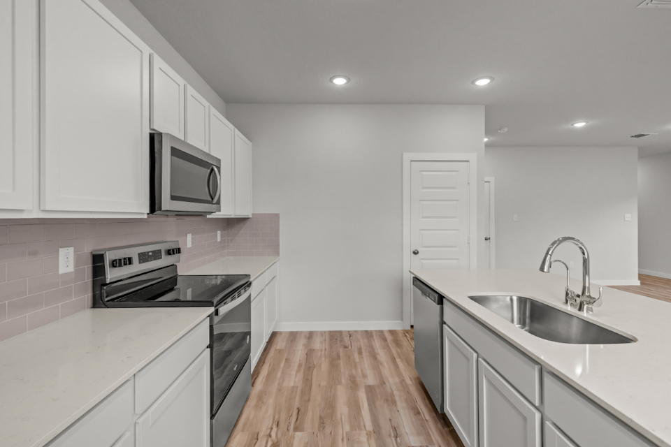 A kitchen with white cabinets.