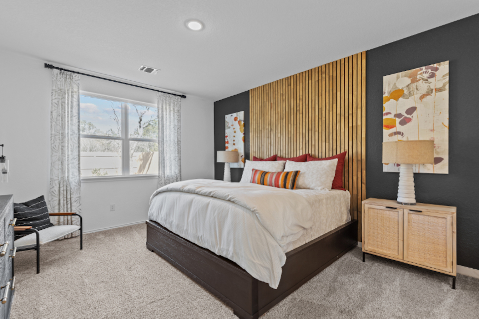 A bedroom with a bed and a chair.
