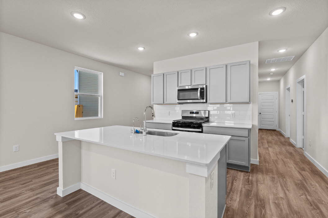 A kitchen with white cabinets.