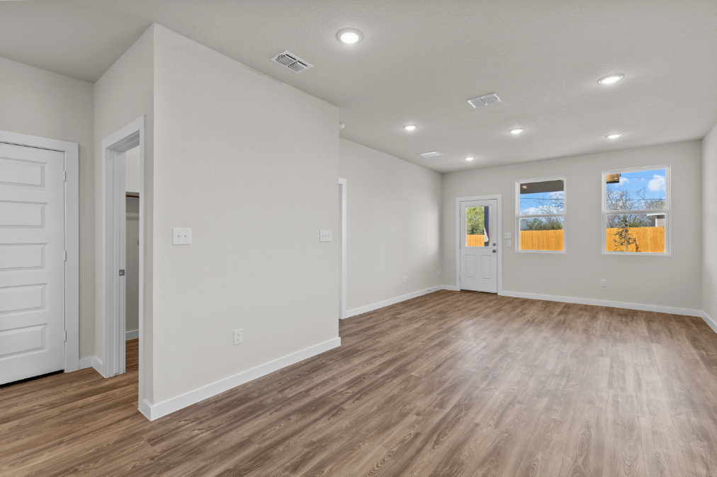 A room with white walls and wood floors.