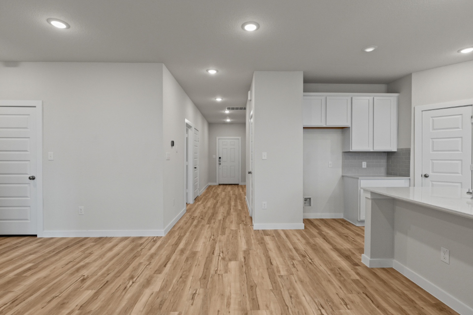 A large empty room with white cabinets.