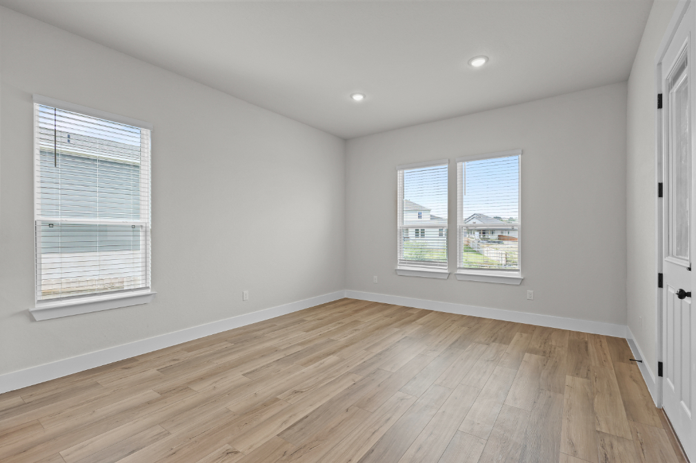 A room with a wood floor and windows.