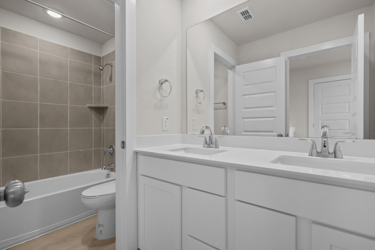 A bathroom with a tub sink and toilet.