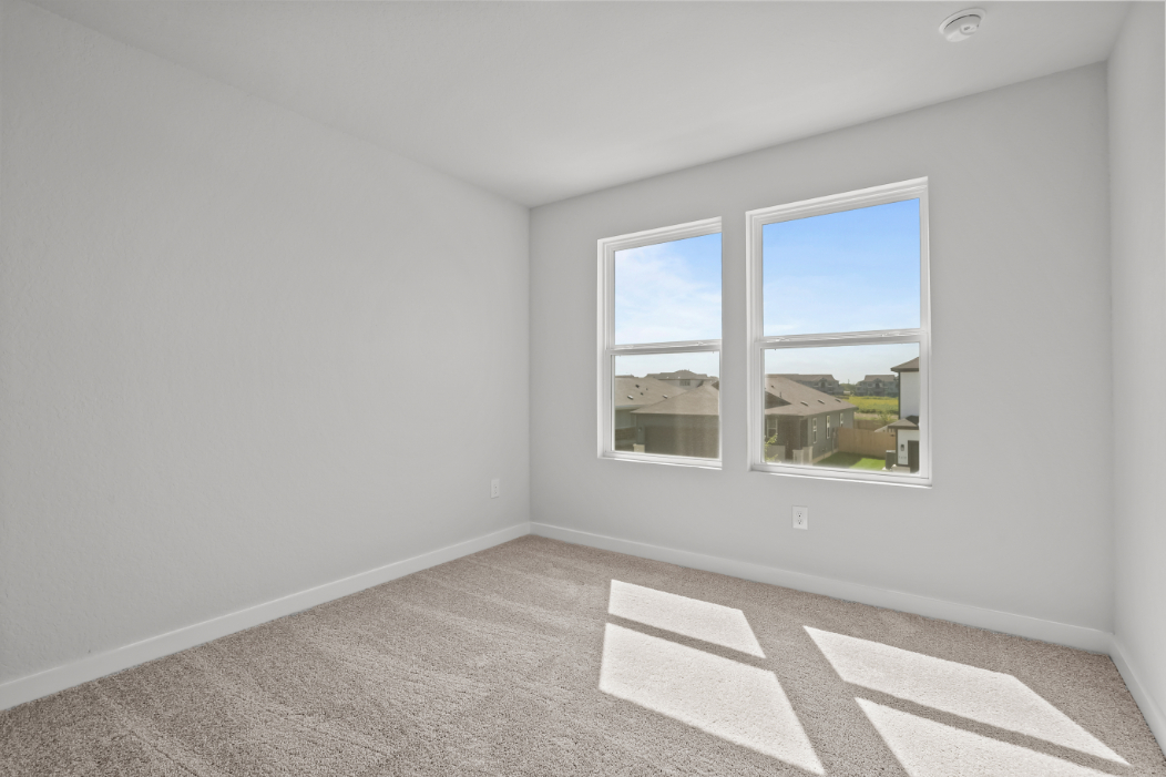 A room with a window and rugs.