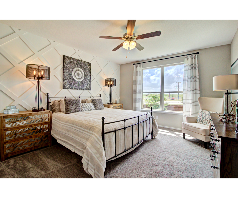 A bedroom with a bed and a fan.