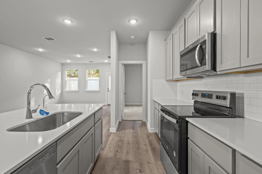 A kitchen with white cabinets.