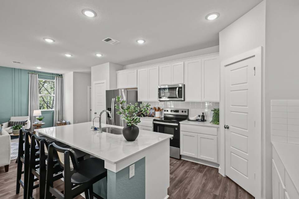 A kitchen with white cabinets.