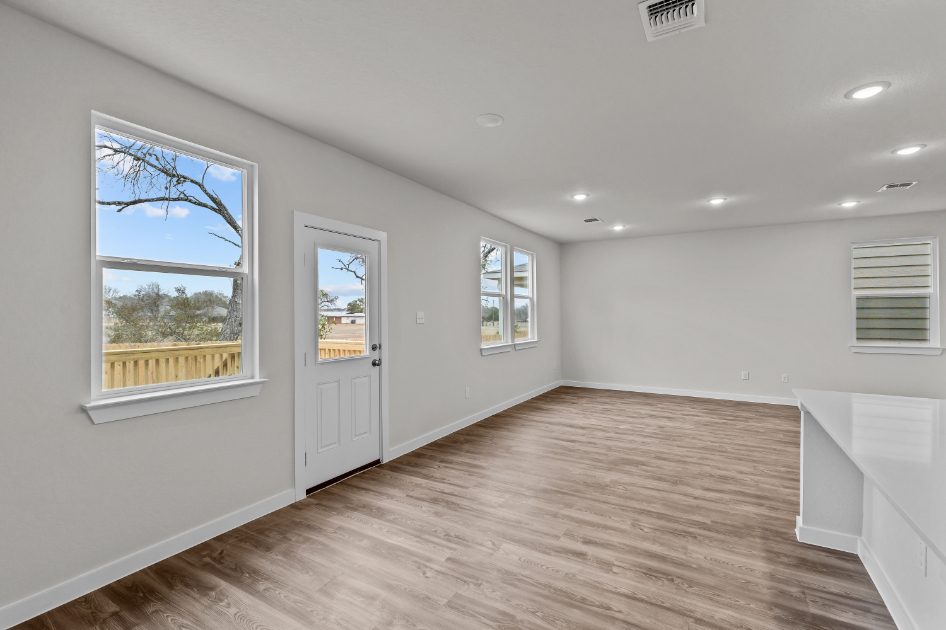 A room with a wood floor and windows.