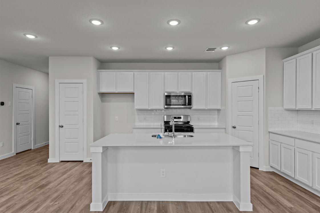 A kitchen with white cabinets.