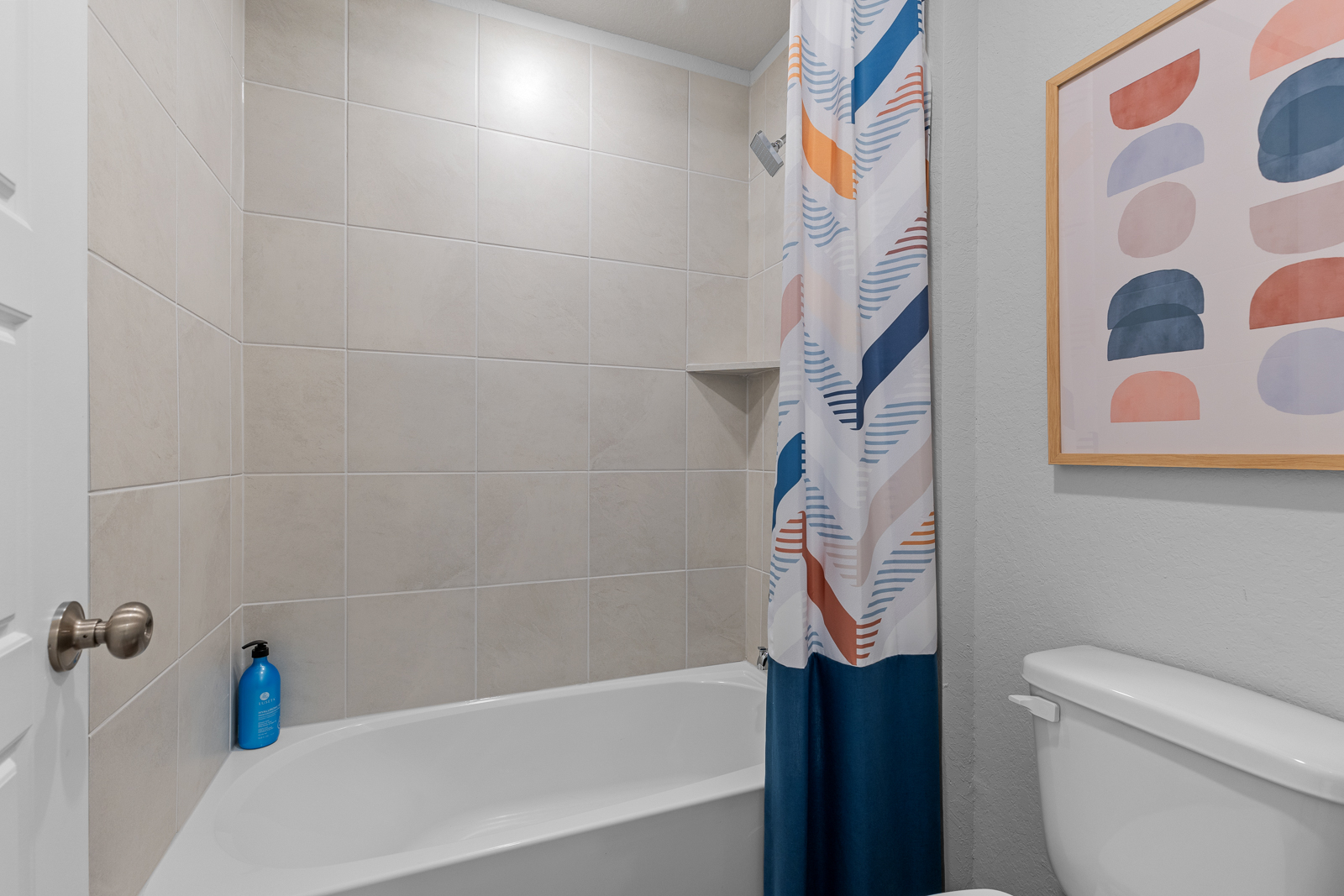 A bathroom with a blue shower curtain.