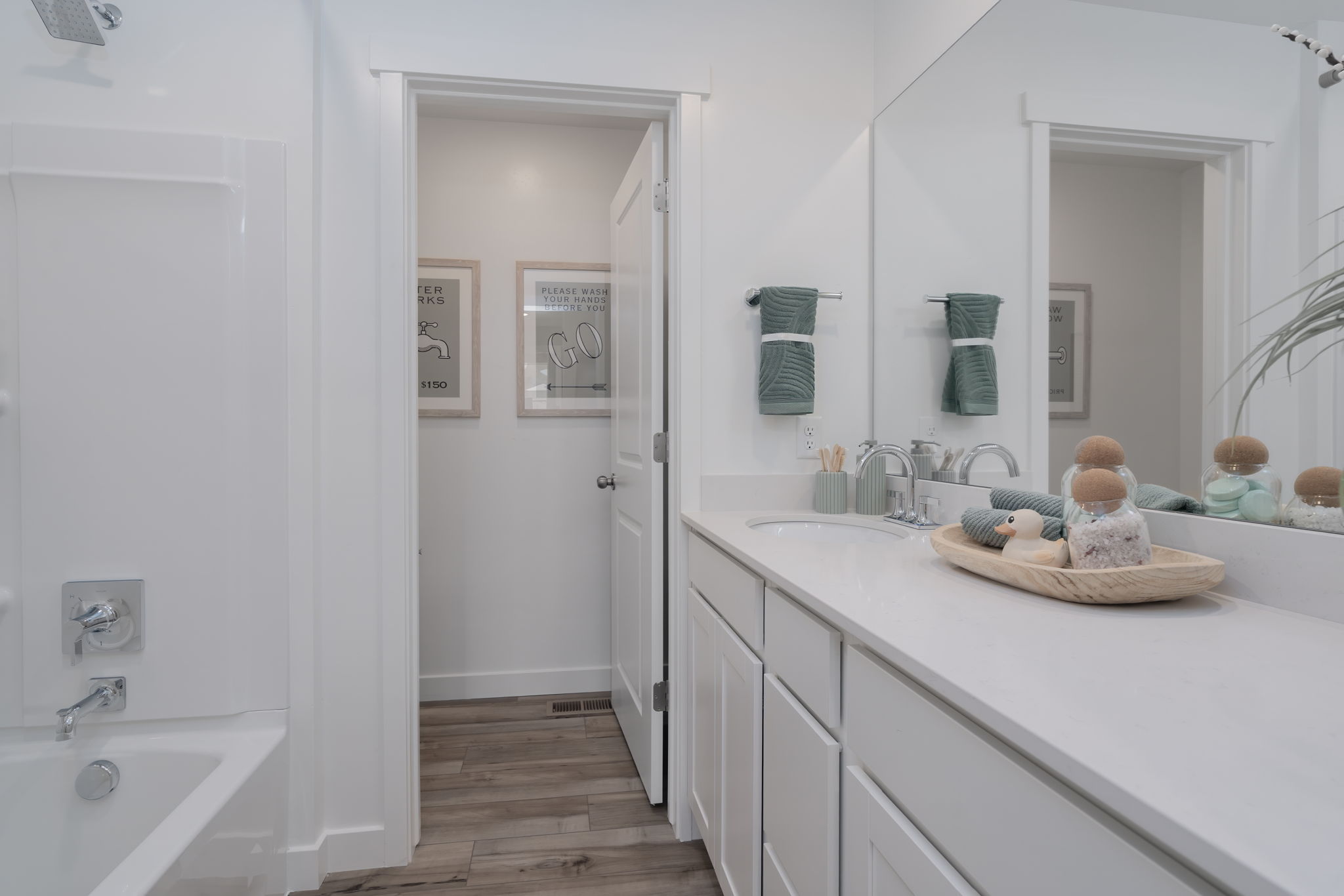 A bathroom with a tub sink and a mirror.