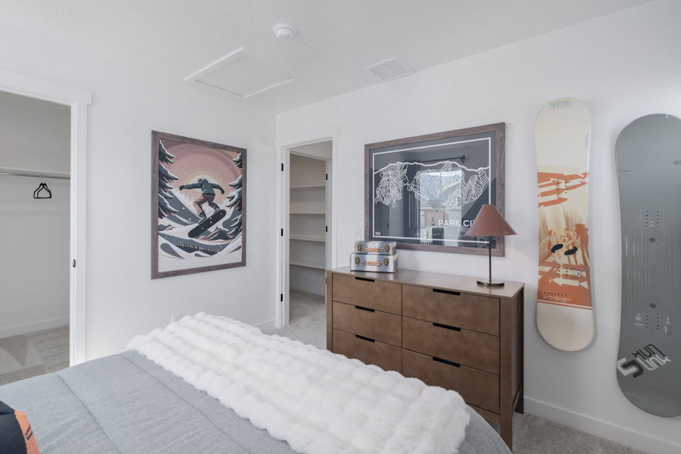 A bedroom with a bed and a dresser.