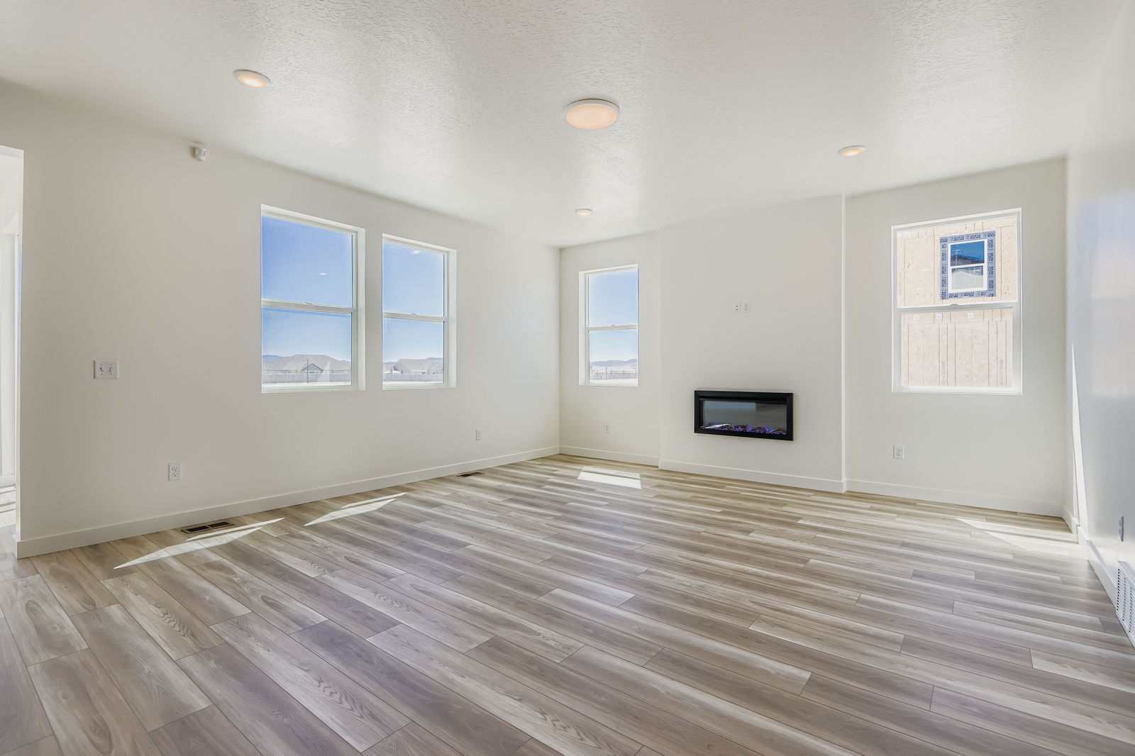 A room with a wood floor and white walls.