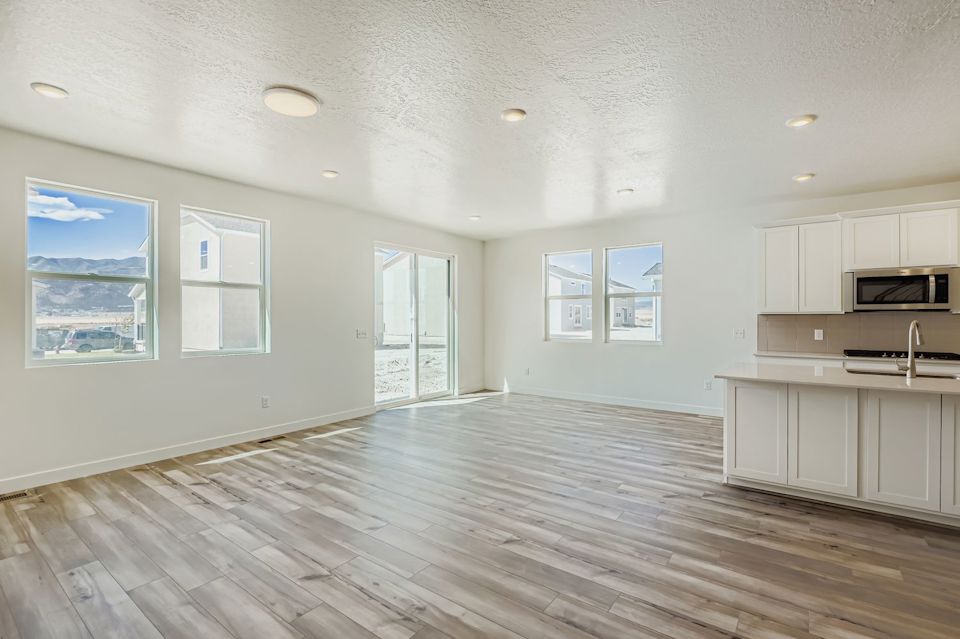 A large empty room with white cabinets.