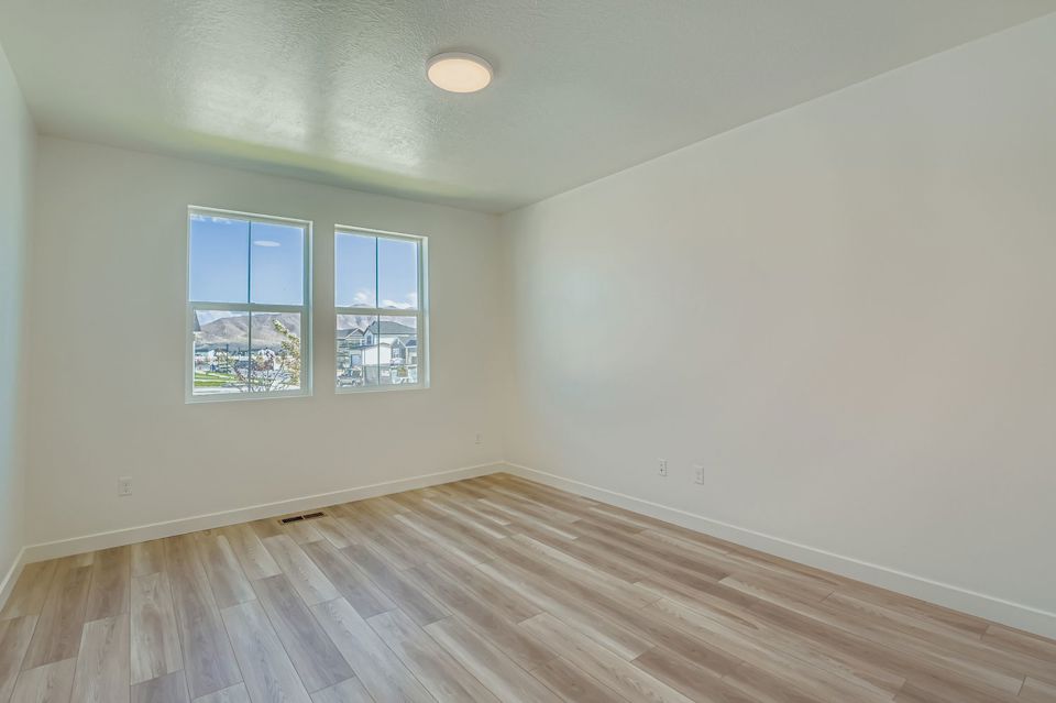 A room with a wood floor and windows.