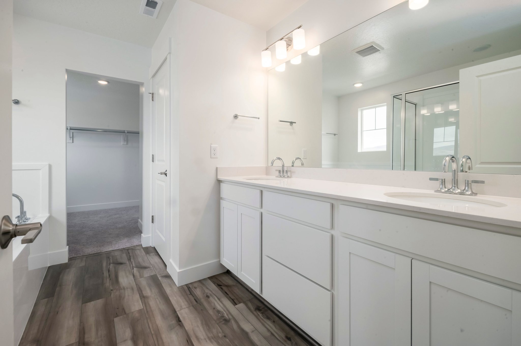A bathroom with white cabinets.