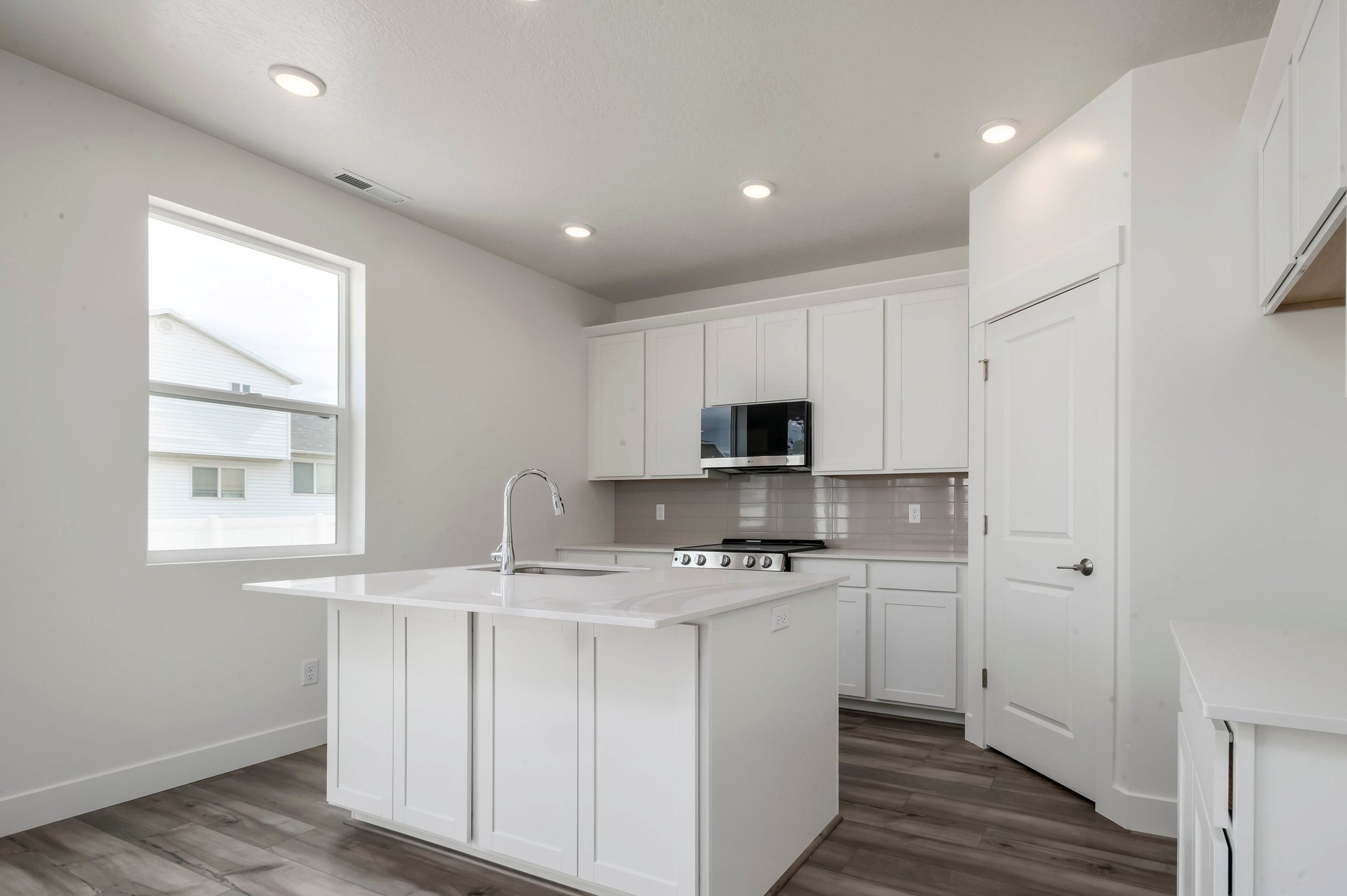 A kitchen with white cabinets.