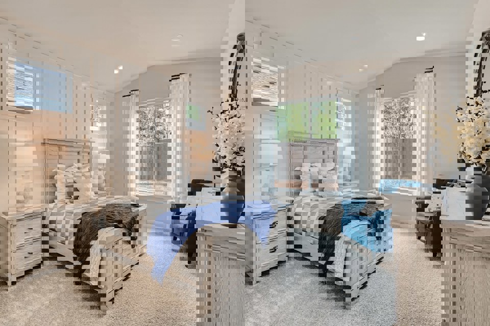 A bedroom with a bed and a chair.