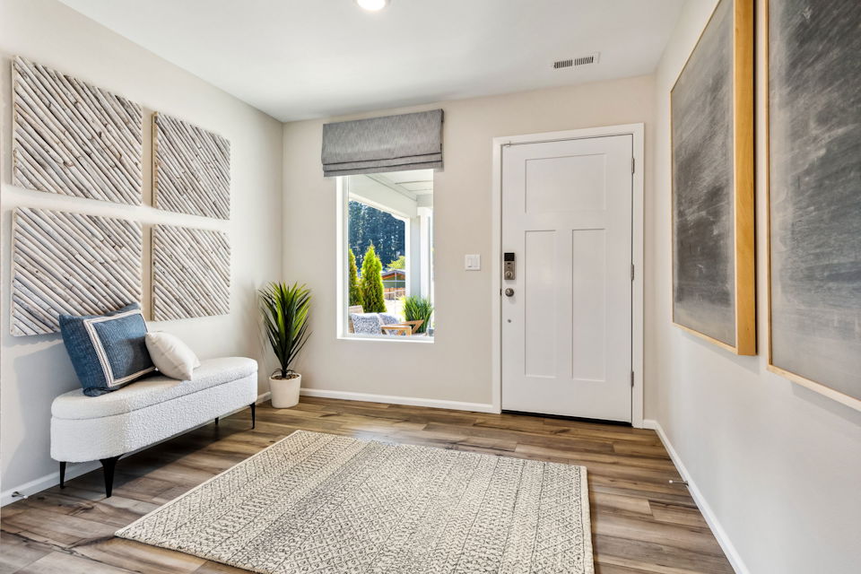 A living room with a white couch and a rug.