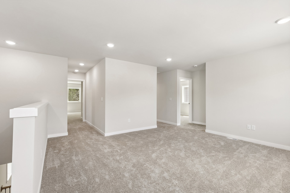 A room with a carpet and a white wall.