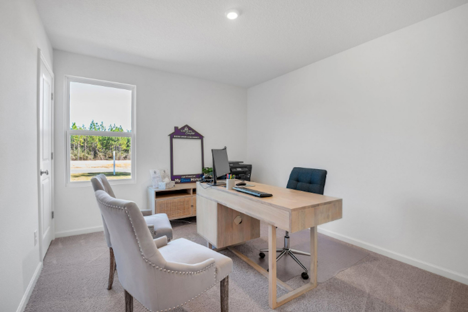 A room with a desk and chairs.