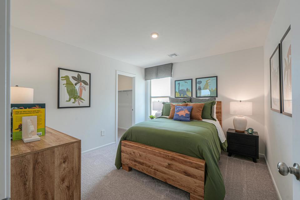 A bedroom with a bed and a table.