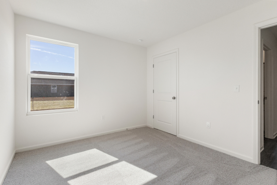 A room with white walls and a window.