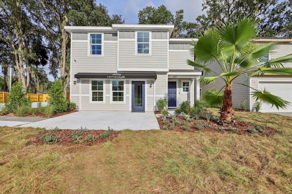 A white house with a palm tree.